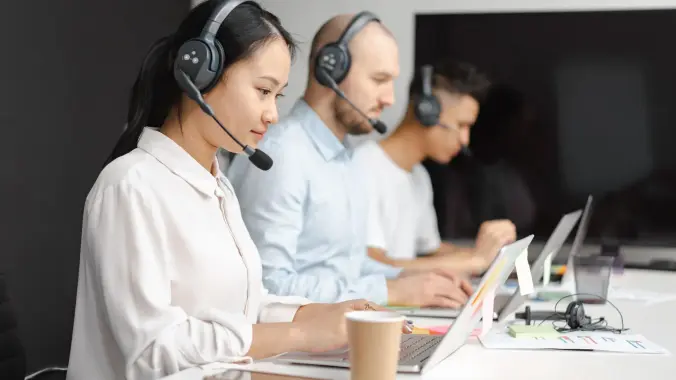 AI conversazionale nel customer service: operatori di un contact center al lavoro con le cuffie